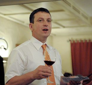 Ein Mann hält drinnen ein Weinglas in der Hand.