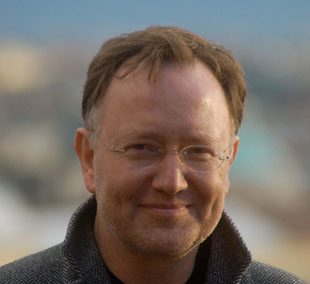 Porträt eines lächelnden Mannes im Freien.